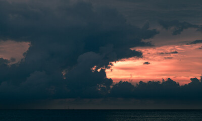 Dark cloudy tropical sunset sky over the ocean, natural background