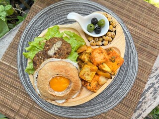 Egg bagel burger with falafel, tofu masala and chic pea with olive