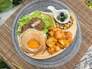 Egg bagel burger with falafel, tofu masala and chic pea with olive