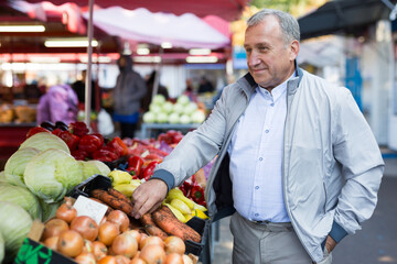 Man choosing carrots in market