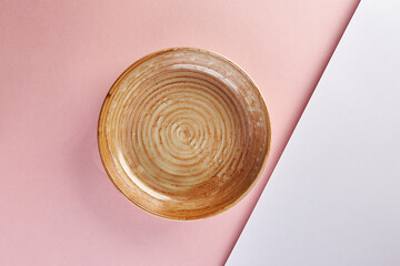 Empty ceramic brown plate on pink background. Mockup, place for text