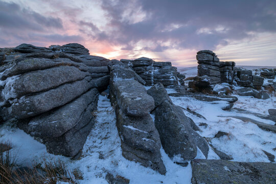 Sunrise over a snow covered East Mill Tor in winter, Dartmoor, Devon