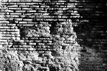 Detail of a wall in Roman structure made of bricks and with the opus reticulatum technique in blocks of porphyry, in the archaeological site of Ostia Antica.	