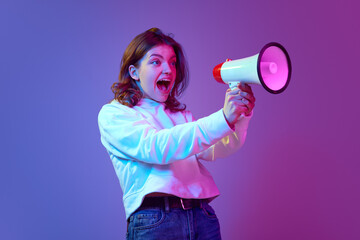Young pretty girl feeling excited and energetic, talking in megaphone loudly against gradient blue purple studio background in neon light. News. Concept of emotions, youth, lifestyle, information