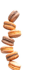 Group of beige macaroons isolated balance  on a transparent background. Vertical photo and copy space.