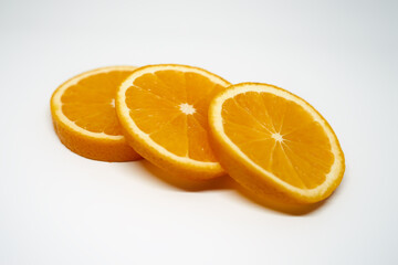 Three slices of ​​orange on white isolated studio background side view