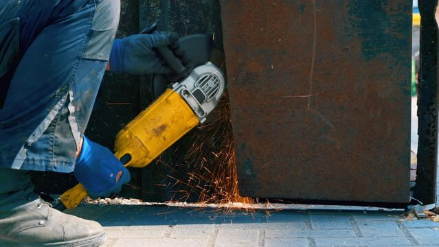 A locksmith works with a metal grinder