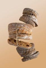 mini ciabatta, tied with string, on a beige background, flying food selective focus