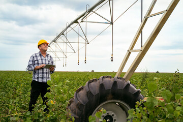 Man agriculture expert, farmer standing near watering systems on the field with digital tablet  © phoenix021