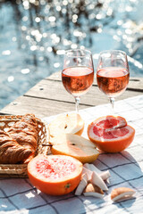 Romantic sunset dinner on the beach. Table honeymoon set for two with luxurious food, glasses of rose wine drinks in a restaurant with sea view. Summer love, romance date on vacation concept.   