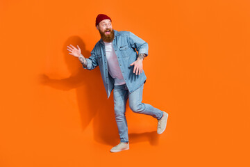 Fototapeta na wymiar Full length photo of cool excited guy dressed denim jacket dancing having fun isolated orange color background