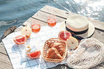Romantic sunset dinner on the beach. Table honeymoon set for two with luxurious food, glasses of rose wine drinks in a restaurant with sea view. Summer love, romance date on vacation concept.   
