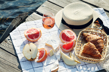 Romantic sunset dinner on the beach. Table honeymoon set for two with luxurious food, glasses of rose wine drinks in a restaurant with sea view. Summer love, romance date on vacation concept.   