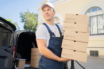 A courier working for a fast delivery company is a man in the city, carrying boxes to the customer...