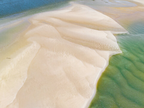 Aerial view of patterns in white sand bars surrounded by blue sea