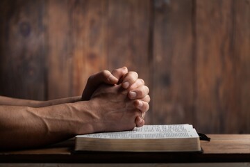 Man hands praying on the bible. Concept religion