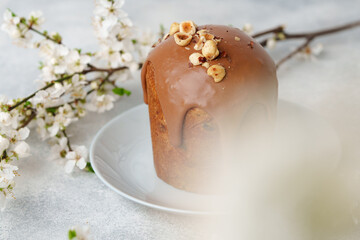 Ester cake with chocolate topping and nuts on gray background