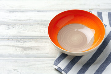 Top view of color ceramic plate on wooden background