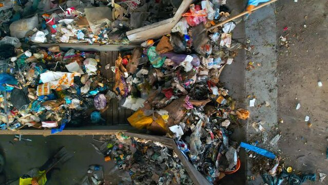 Workers loading garbage onto a conveyor belt at waste sorting plant. Slow motion