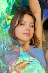 Young woman posing with holographic foil. Dreamy self expression concept beauty portrait	