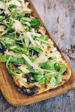 rustic vegetarian pizza with mushroom and rocket leaves