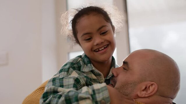 Loving multiracial father embracing son with Down syndrome
