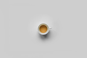 Half empty coffee cup isolated over white background top view. Small ceramic mug with unfinished caffeine beverage on wooden table.