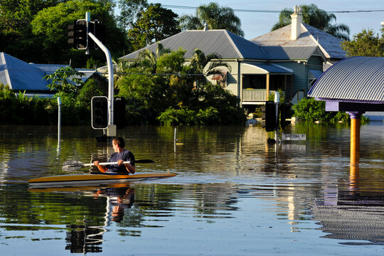 Flooded residential street with man in a canoe