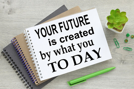 business concept. There are three notebooks on the work table near a plant in a pot with text-Your future is created by what you do today