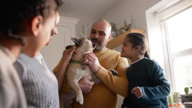 Family and boy with Down syndrome stroking dog