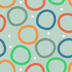 Multi-colored circles on a green background. Vector seamless background, attractive design, childish doodles suitable for general background.