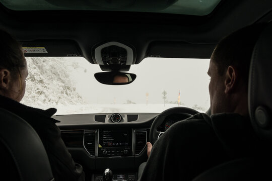 Couple Driving Car On Icy Roads In The Mountains