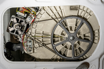Electric motor and belt drive of an electric washing machine