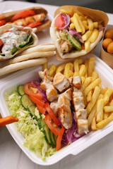 Greek kalamaki and pita gyros with grilled meat served for take away in a fast food restaurant