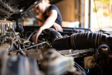 mechanic working on car engine in auto repair garage