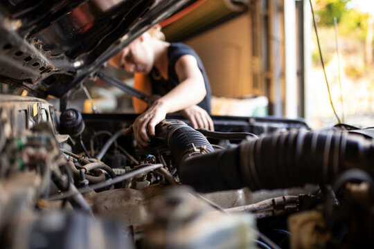 tradesperson mechanic working on car engine in auto repair garage