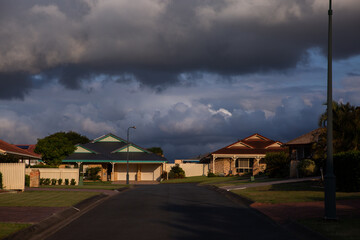 suburban houses under a storm cloud