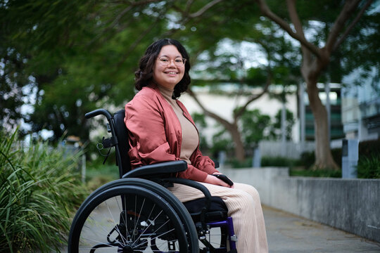 Happy woman in wheelchair outdoors