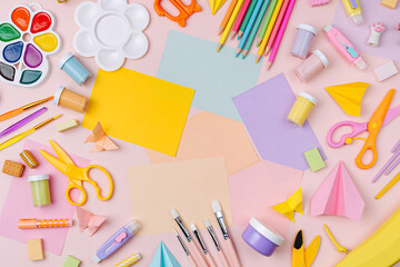 Pink pastel background with various colorful material for creativity and art activity.  Stationery and supplies for drawing and craft with .copy space.  Primary School or kindergarten.