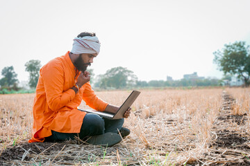 Young indian farmer in depression after see some detail in laptop. - obrazy, fototapety, plakaty