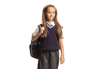 Schoolgirl in a uniform carrying a backpack and smiling at camera