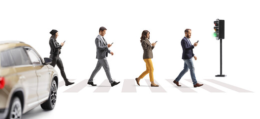 People crossing street at a pedestrian crossing and using mobile phones  and a car waiting