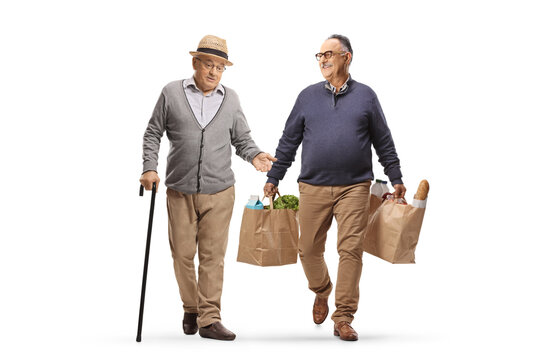Mature man walking, carrying grocery bags and having a conversation with a pensioner - Powered by Adobe