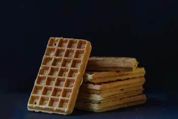 Belgian waffles on black stoneplate and black background