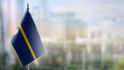 Small flags of the Nauru on an abstract blurry background