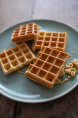 Fresh baked waffle in a pattern on wooden background, top view