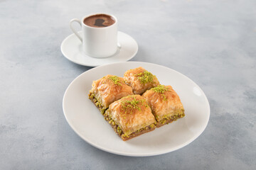 Pistachio baklava on a white plate with Turkish coffee,top view