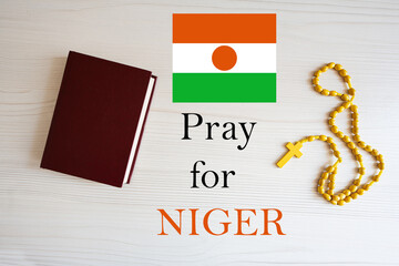 Pray for Niger. Rosary and Holy Bible background.