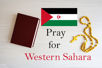 Pray for Western Sahara. Rosary and Holy Bible background.