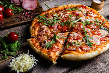 Appetizing pizza with ham on a wooden background